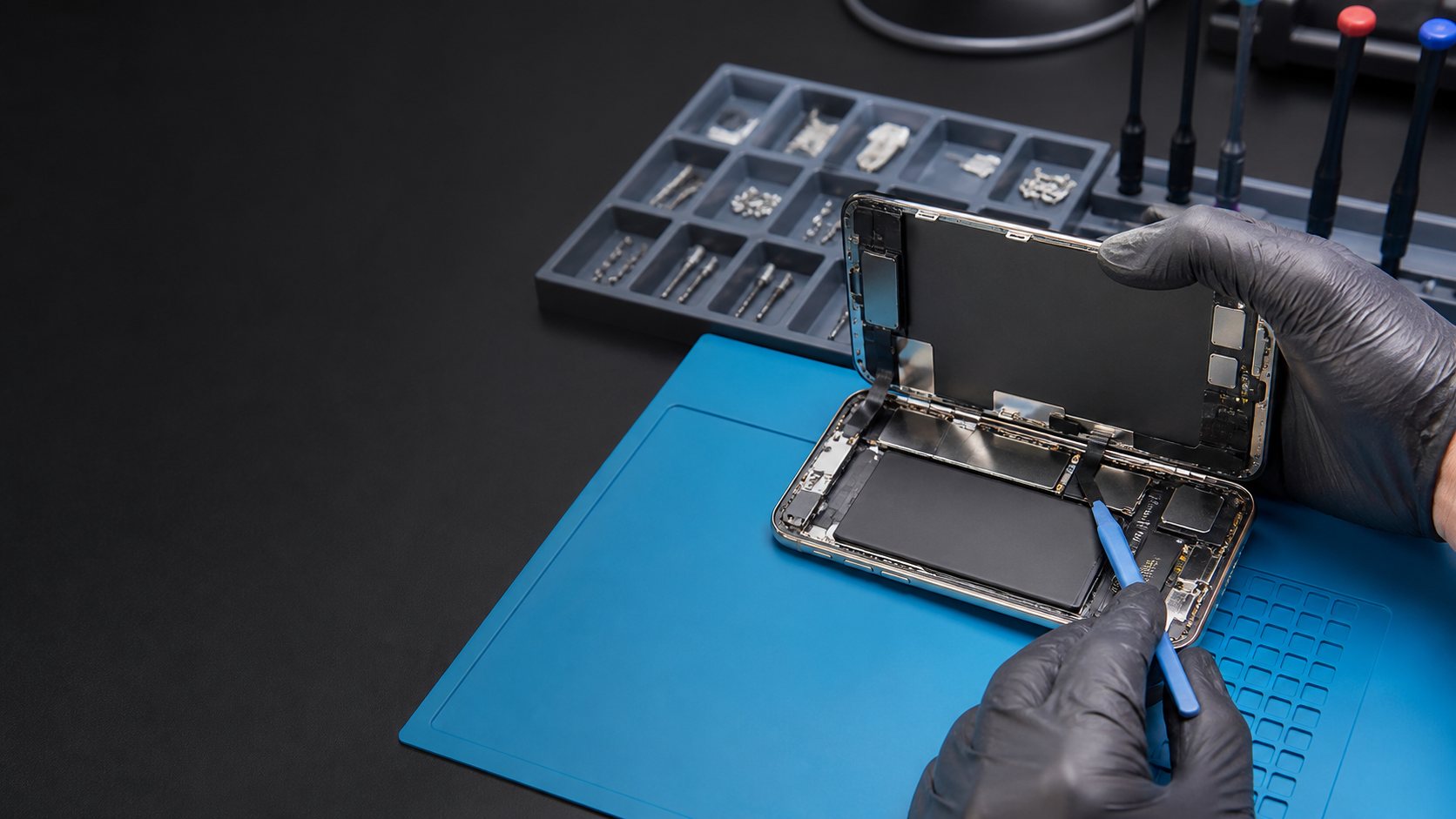 Technician inspecting a smartphone battery during a repair